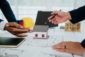 10-Questions-to-Ask-Before-Hiring-a-Custom-Home-Builder---Homeowner-meeting-with-a-custom-home-builder-reviewing-blueprints